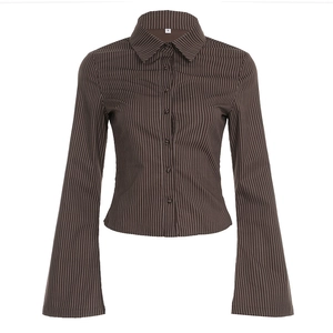 Close-up of brown striped cotton shirt featuring vintage flared cuffs and waist detail