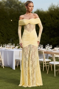 Detail of light yellow off-shoulder lace dress with pleated fabric on a garden setting