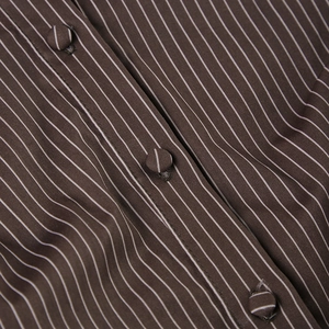 Detail of vertical brown stripes on cotton shirt with matching fabric-covered buttons