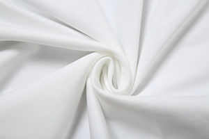 Macro shot of white woven fabric showing fine twill texture and elegant spiral drapery