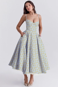 Détail de robe à fleurs bleu clair avec fines bretelles et couche de tulle au bas