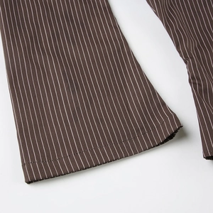 Close-up of dark brown vertical striped cotton trousers with precise hem stitching detail