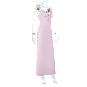 Détail de robe longue rose clair montrant le col en V avec volants et nœud de serrage