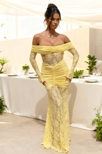 Detail of elegant yellow lace evening dress showing intricate floral cutouts and texture