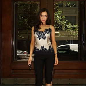 Champagne satin tank top with black lace trim paired with slim black cropped trousers