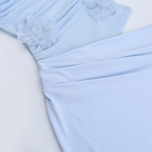 Détail de robe plissée bleu clair avec appliques florales en maille 3D et paillettes