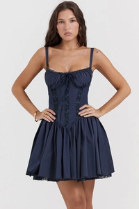 Detail of the navy blue corset dress showing lace trim, drawstring bow, and pleated skirt