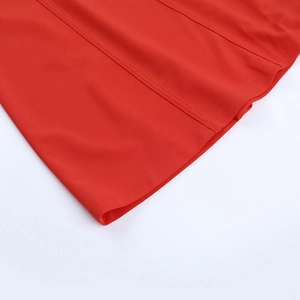 Détail de l'ourlet de la robe rouge montrant les doubles surpiqûres et les coutures verticales
