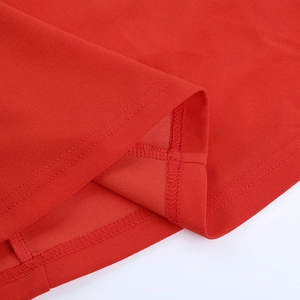 Détail de l'ourlet de robe rouge avec couture à double aiguille et finition surjetée de qualité