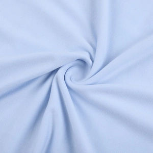 Gros plan sur un tricot bleu clair avec une texture tissée fine et un drapé souple