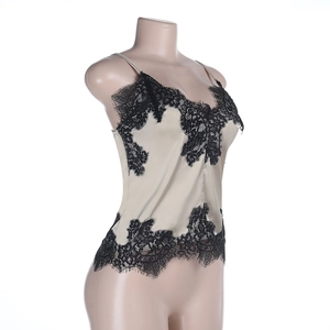 Detail of champagne satin crop top with delicate black eyelash lace trim and silk texture