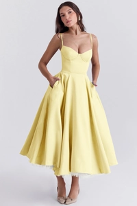 Détail de la robe corset jaune clair à fines bretelles et jupe plissée évasée