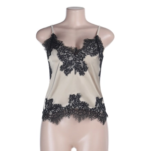 Detail view of champagne satin camisole featuring intricate black lace trim on a mannequin