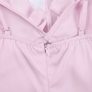 Vue macro du dos d'une robe rose avec fermeture éclair invisible et bretelles volantées