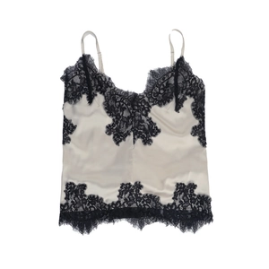 Detail of cream satin camisole featuring delicate black eyelash lace trim and thin straps