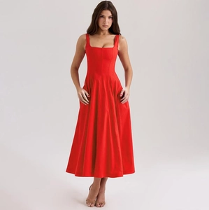 Détail d'une robe midi rouge sans manches avec décolleté carré et jupe plissée ample