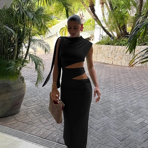 Détail de robe noire avec découpes asymétriques à la taille et ruban à l'épaule