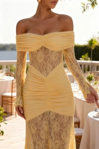 Detail view of the elegant lace stitching and pleated texture on the light yellow dress