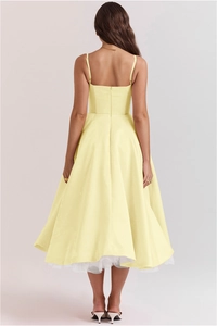 Détail du dos nu élégant et de l'ourlet en tulle double épaisseur de la robe jaune chic