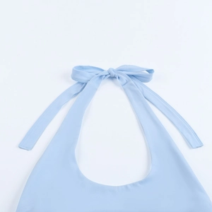 Detail der himmelblauen Halterneck-Schleife an einem schimmernden Partykleid