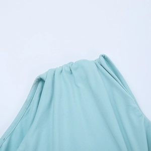 Gros plan sur le détail torsadé à l'épaule d'une robe de soirée bleu menthe pailletée
