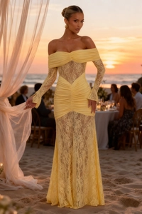 Pale yellow off-shoulder lace maxi dress with mermaid hem shown at sunset beach