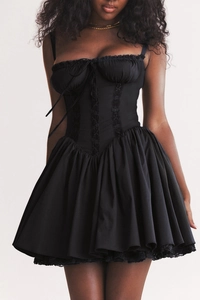Close-up of black corset dress featuring lace trim and ribbon bow detail on the bodice