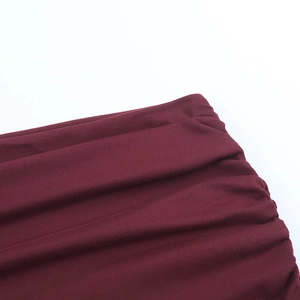 Detail view of burgundy ruched fabric with subtle glitter and elasticated knit texture