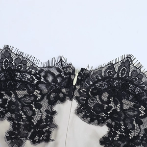 Detail of delicate black eyelash lace trim and hidden zipper on ribbed crop top