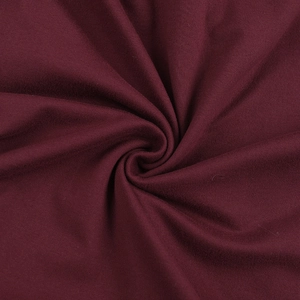 Macro detail of the wine red sparkling fabric texture and soft draped folds of the party dress