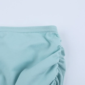 Détail de robe en tricot bleu clair montrant les fronces et les coutures de la taille