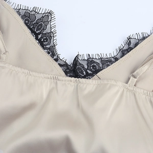 Detail of champagne satin tank top featuring black eyelash lace trim and adjustable straps