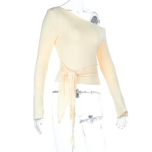 Détail du haut moulant à une épaule jaune clair avec nœud de ceinture à la taille