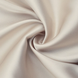Detailed macro view of champagne silk fabric shaped into a soft rose petal texture