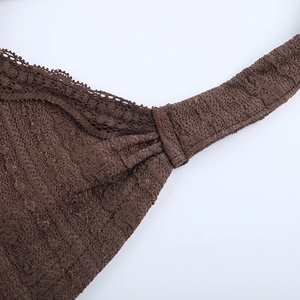Vue détaillée du tissu en dentelle marron foncé avec textures florales délicates