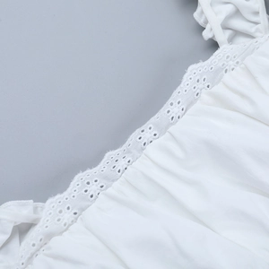 Close-up of white T-shirt featuring intricate eyelet lace embroidery and pleated texture