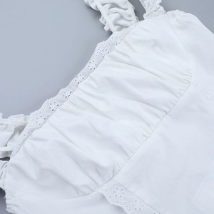 Detailed close-up of white T-shirt featuring hollow lace trim and pleated cotton fabric texture