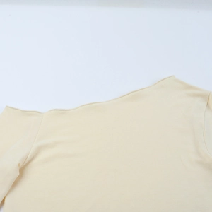Vue détaillée du décolleté asymétrique de ce haut jaune pâle à coupe ajustée