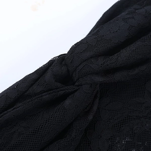 Detail shot of the elegant black floral lace fabric and the twisted knot design of the headband