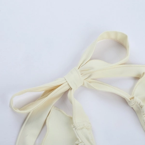 Détail d'un haut dos nu beige avec nœud papillon et finitions de couture de qualité