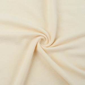 Détail macro du tissu en maille côtelée blanc crème montrant texture douce et élasticité