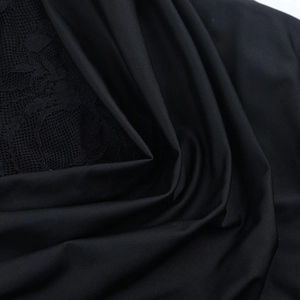 Close-up of black strapless dress fabric featuring elegant lace and plain weave texture