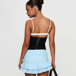 Detail view of light blue pleated mini skirt with layered ruffle hem and back pocket