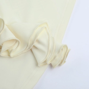 Gros plan sur la bordure ondulée et la texture du tricot crème du haut d'été pour femme