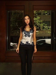 Elegant white satin crop top with black floral lace trim and high neck sleeveless design