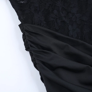 Close-up of black floral lace fabric and ruched texture on a strapless party dress