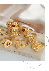 Détail de bagues cœur en or vintage avec zircons rouges et blancs sur présentoir