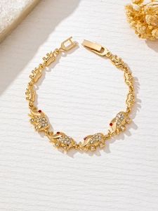 Detailed view of golden elephant bracelet with white crystals and red gem eyes
