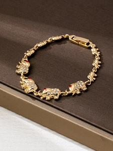 Detail of golden elephant bracelet links with sparkling white and red crystals