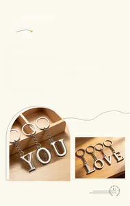 Close-up of a silver metal alphabet keychain on a wooden tray with natural lighting
